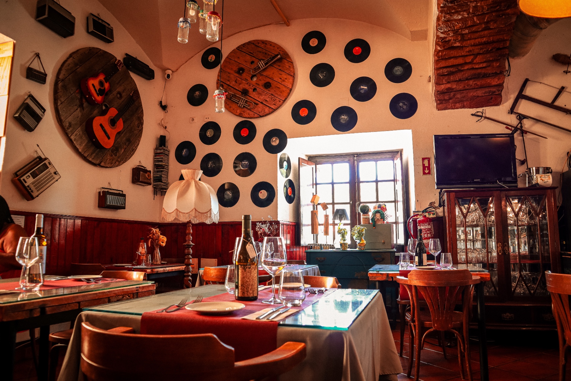 Sala da música com vinis, guitarras e mesas postas