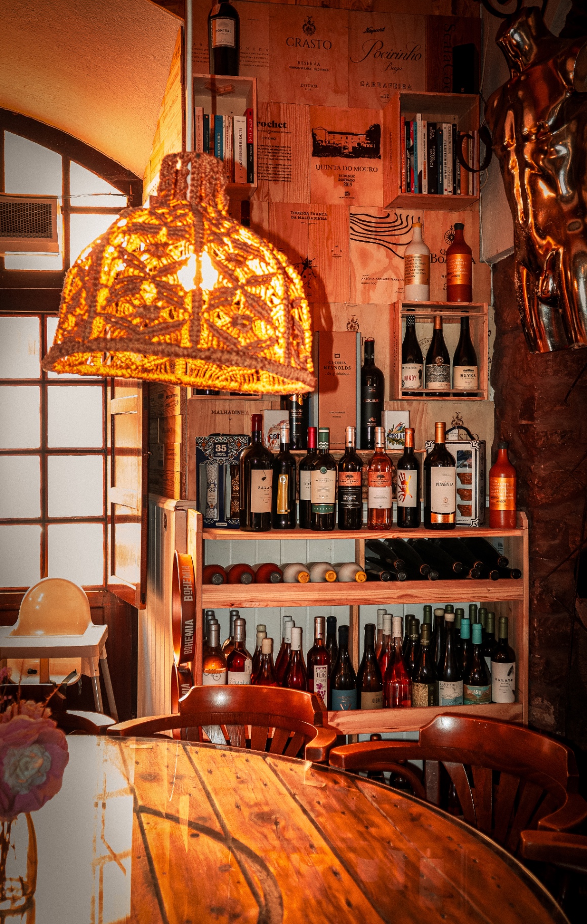 Parede de caixas de vinho com prateleiras e livros