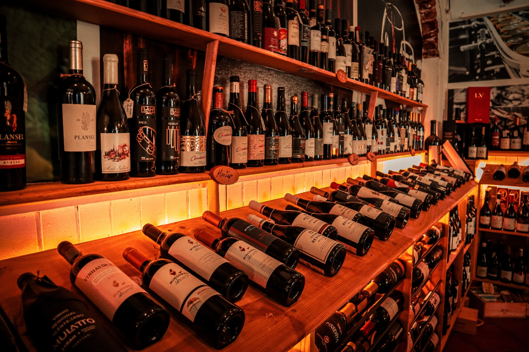 Prateleiras iluminadas com garrafas de vinho